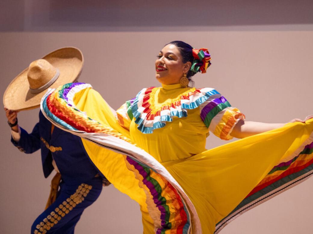 Two Ballet Folklorico performers dance in traditional dress.